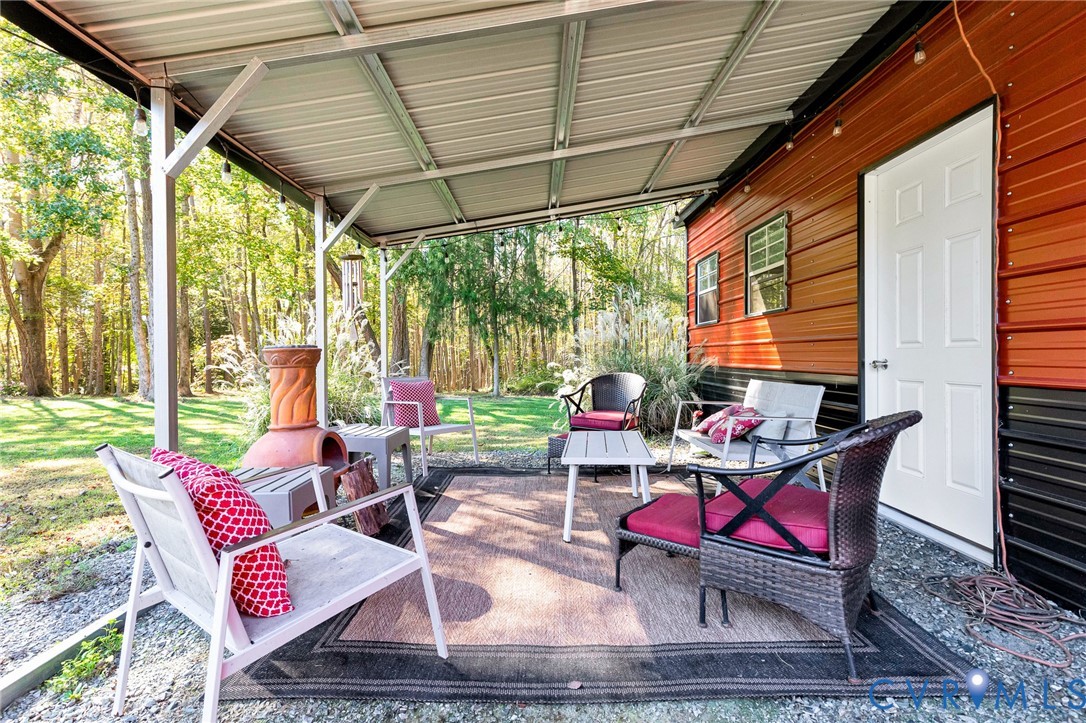Covered outdoor patio with a metal roof, two-tone metal exterior siding, and gravel flooring