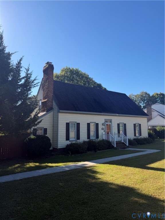 Exterior featuring light-colored horizontal siding, dark window shutters, an asphalt shingle roof, and an exposed masonry chimney Exterior featuring light-colored horizontal siding, dark window shutters, an asphalt shingle roof, and an exposed masonry chimney