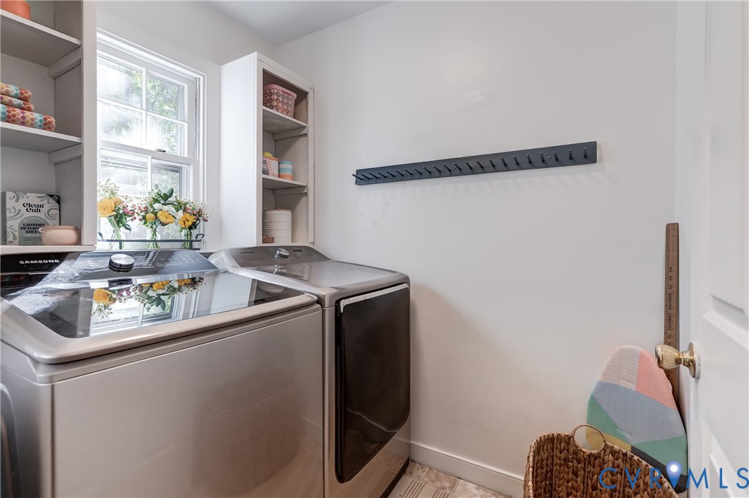 Laundry area featuring custom white built-in shelving, a single-hung window, and a wall-mounted hook rail