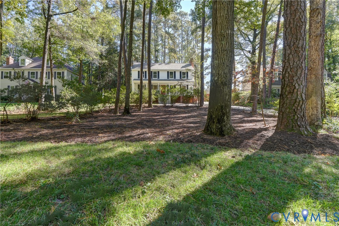 Wooded lot featuring mature trees and a mixture of lawn and mulched ground cover Wooded lot featuring mature trees and a mixture of lawn and mulched ground cover