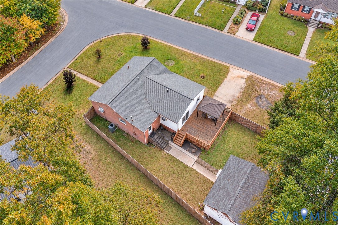 Single-story residence featuring a red brick exterior, dark-toned shutters, a gabled roofline, and an expansive lawn