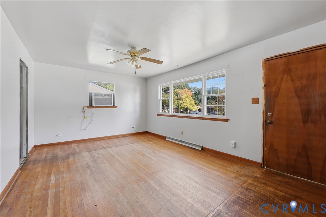 Interior space featuring wood-finish flooring, a multi-pane window, and a central ceiling fan