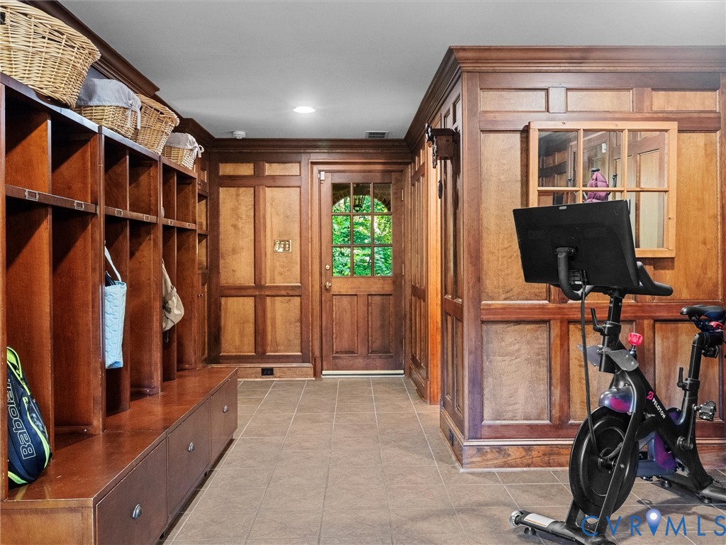 Custom wood paneling, extensive built-in cabinetry with individual storage cubbies, and a wood entry door featuring multi-pane glass inserts and an arched top