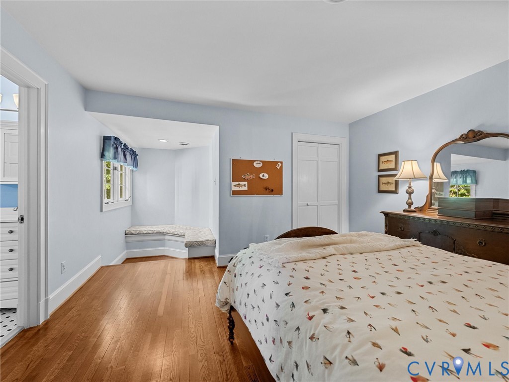 Room featuring wood-finish flooring, a built-in window seat, recessed lighting, and a double-door closet