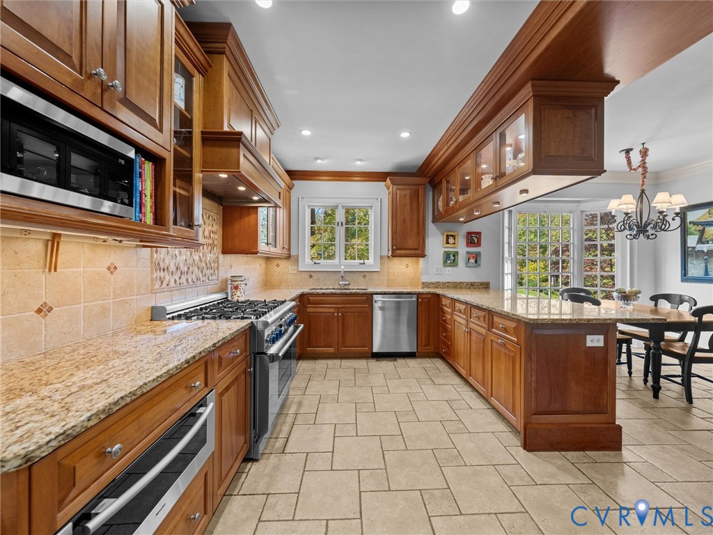 Kitchen featuring custom wood cabinetry, stone countertops, tiled flooring, stainless steel gas range, and recessed lighting