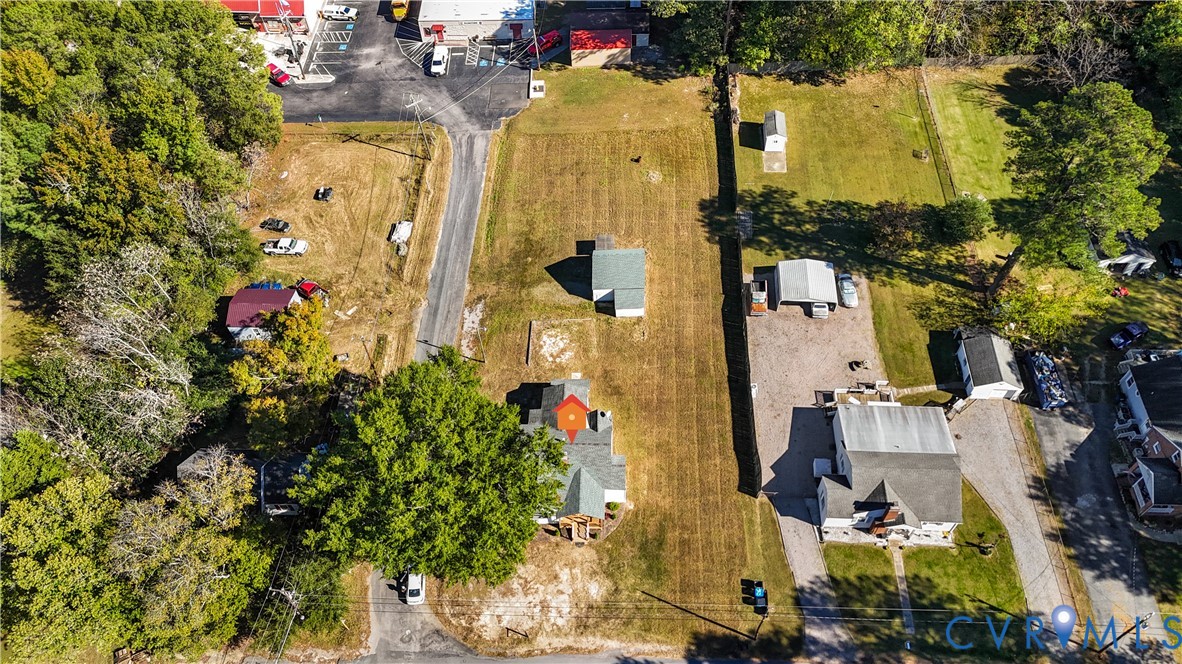Aerial view of property featuring an expansive lot, mature trees, and existing structural footprint
