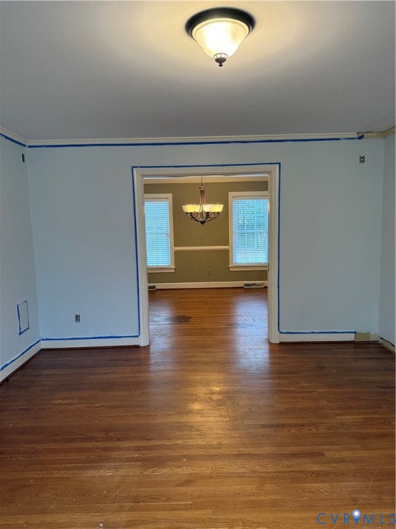 Hardwood flooring, multi-light chandelier, chair rail molding, and flush-mount ceiling lighting