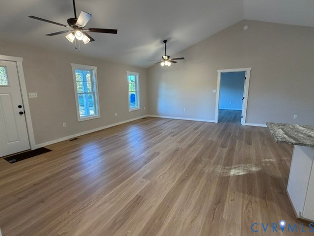 Vaulted ceilings, wood-finish flooring, dual ceiling fans with integrated lighting, and energy-efficient windows