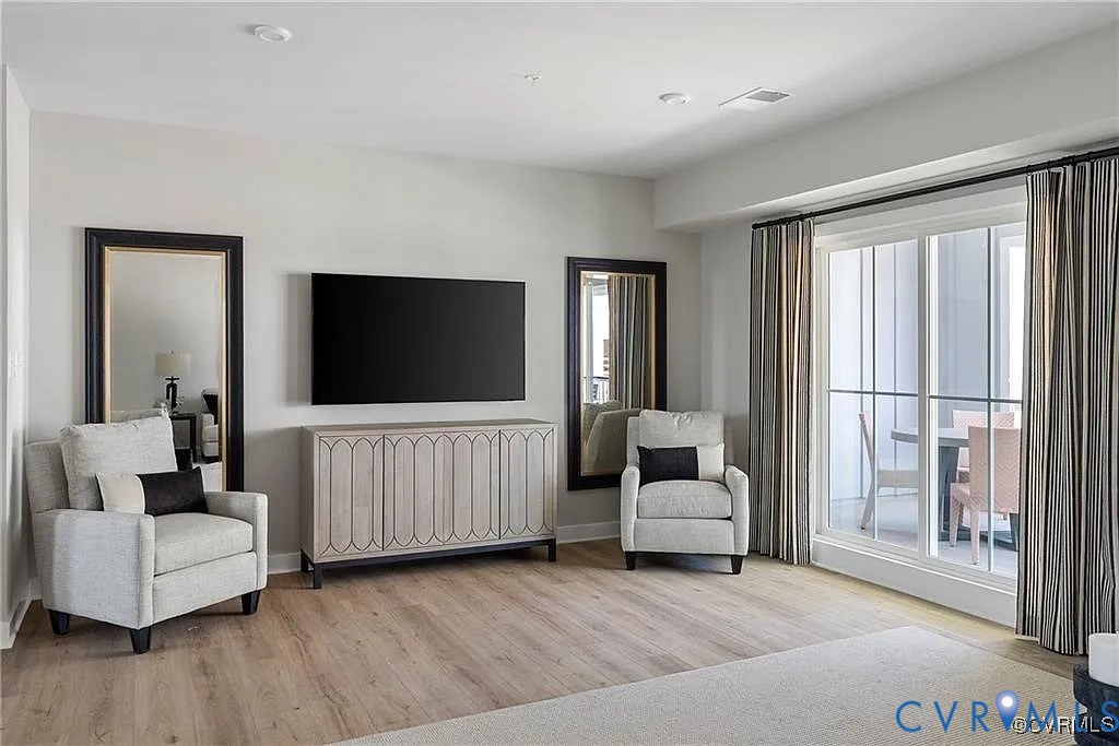 Interior space featuring wood-finish flooring, recessed lighting, and a floor-to-ceiling glass sliding door providing exterior access Interior space featuring wood-finish flooring, recessed lighting, and a floor-to-ceiling glass sliding door providing exterior access