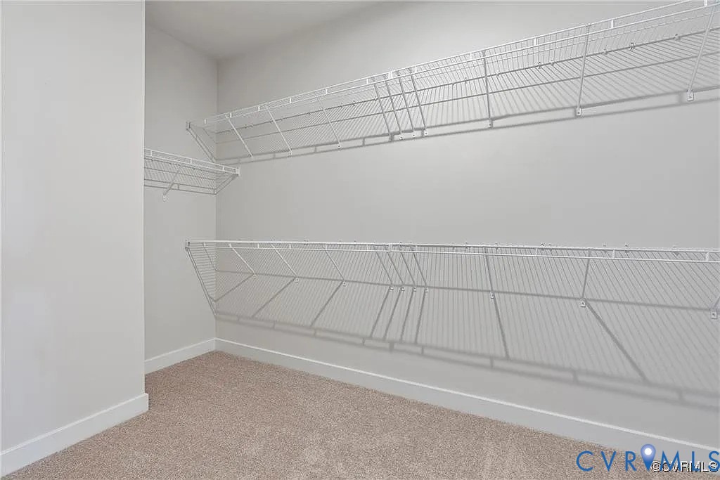 Storage area featuring wall-to-wall carpeting and dual-level white wire shelving Storage area featuring wall-to-wall carpeting and dual-level white wire shelving