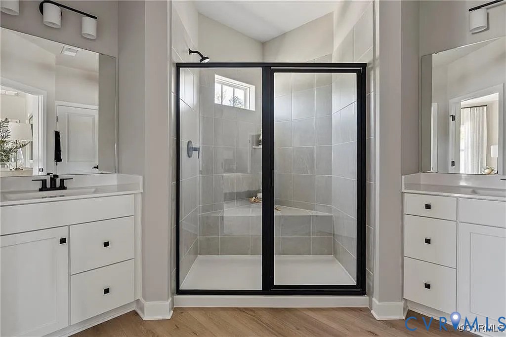 Double vanity with white cabinetry, square undermount sinks, matte black fixtures, and large mirrors