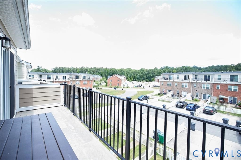Elevated balcony featuring a black metal railing and concrete flooring