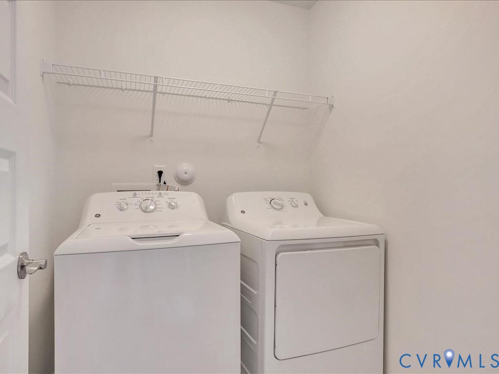 Laundry area featuring a wall-mounted wire storage shelf and dedicated appliance hookups Laundry area featuring a wall-mounted wire storage shelf and dedicated appliance hookups