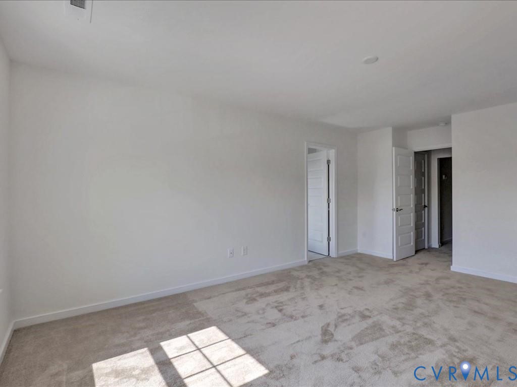 Neutral interior featuring wall-to-wall carpeting, high-gloss white interior doors, and clean, minimalist wall finishes