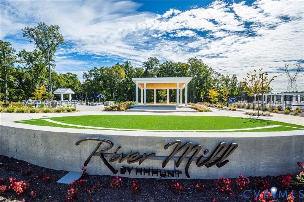 Community grounds featuring a concrete retaining wall, manicured turf lawn, open-air pavilion, and landscaped beds Community grounds featuring a concrete retaining wall, manicured turf lawn, open-air pavilion, and landscaped beds