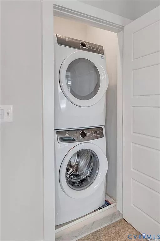 Stacked front-loading washer and dryer set enclosed within a dedicated closet featuring a multi-panel door Stacked front-loading washer and dryer set enclosed within a dedicated closet featuring a multi-panel door