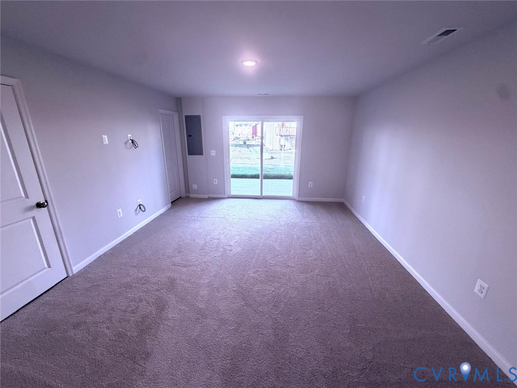 Neutral-toned room featuring wall-to-wall carpeting, recessed lighting, and sliding glass doors leading to the exterior Neutral-toned room featuring wall-to-wall carpeting, recessed lighting, and sliding glass doors leading to the exterior