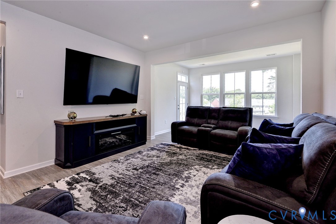 Neutral interior featuring wood-finish flooring, recessed lighting, and multi-pane windows