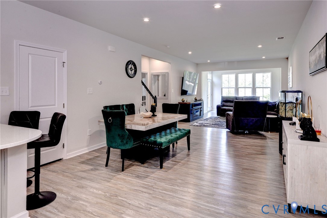Open-concept interior featuring wood-finish flooring, recessed lighting, and expansive windows