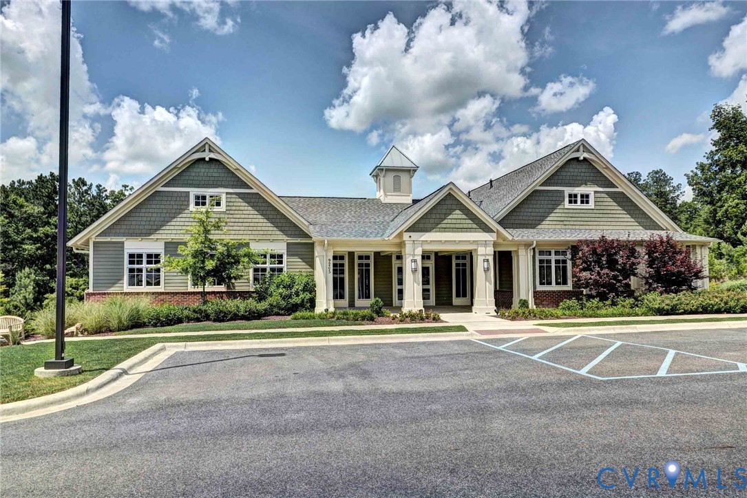 Craftsman-style exterior featuring shake siding, a central cupola, multi-gabled roofline, covered entryway with decorative columns, and brick foundation accents