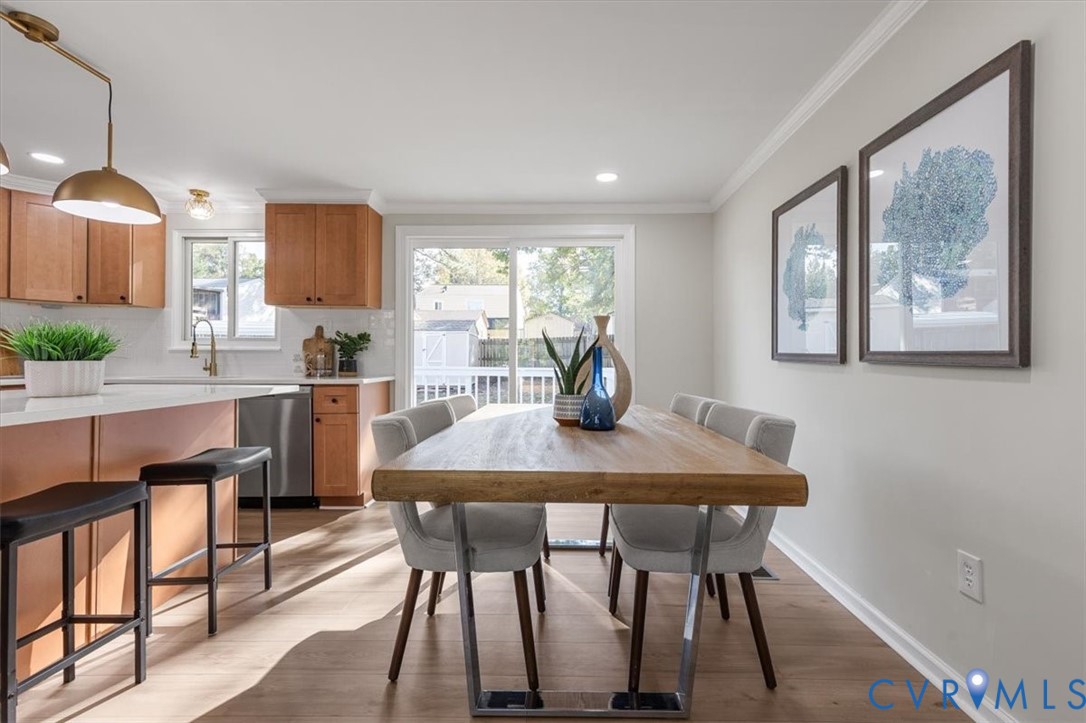 Kitchen featuring wood cabinetry, an island with stone-finish countertop, recessed lighting, brass-finish pendant lighting, and wood-finish flooring
