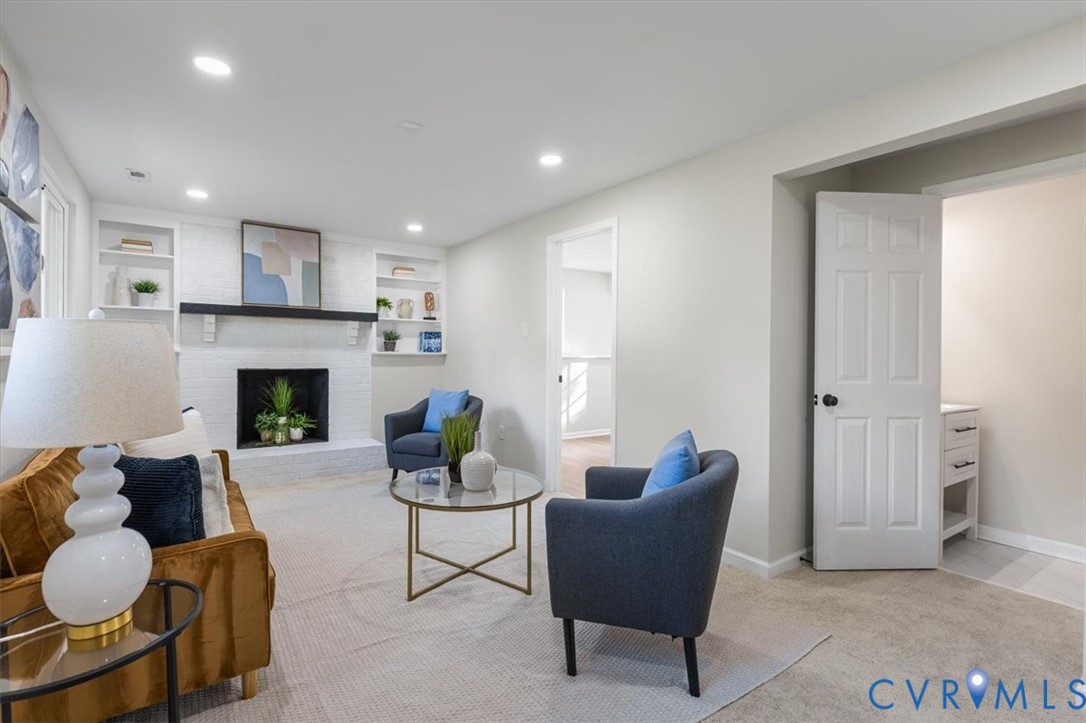Painted brick fireplace with a dark mantel, built-in shelving, and recessed lighting