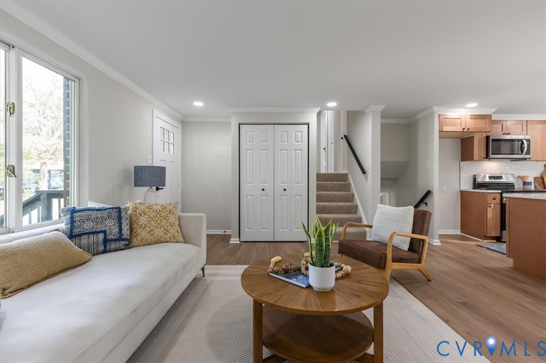 Living area featuring wood-finish flooring, recessed lighting, and crown molding
