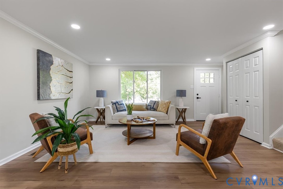 Neutral-toned interior featuring wood-finish flooring, recessed lighting, and double-panel closet doors Neutral-toned interior featuring wood-finish flooring, recessed lighting, and double-panel closet doors