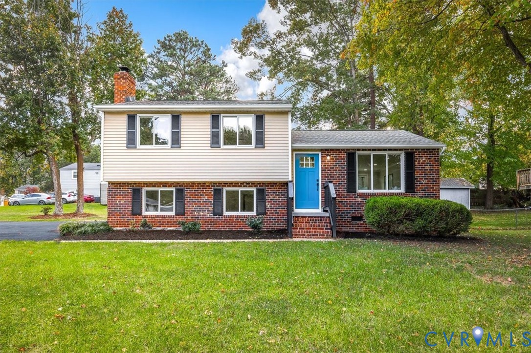 Multi-level exterior featuring a brick and horizontal siding facade, a front-entry door with glass detailing, and black decorative window shutters Multi-level exterior featuring a brick and horizontal siding facade, a front-entry door with glass detailing, and black decorative window shutters