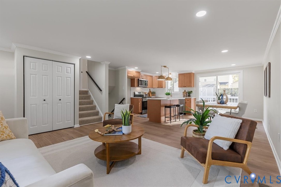 Open-concept interior featuring wood-finish flooring, recessed lighting, and a kitchen equipped with a central island and natural wood cabinetry