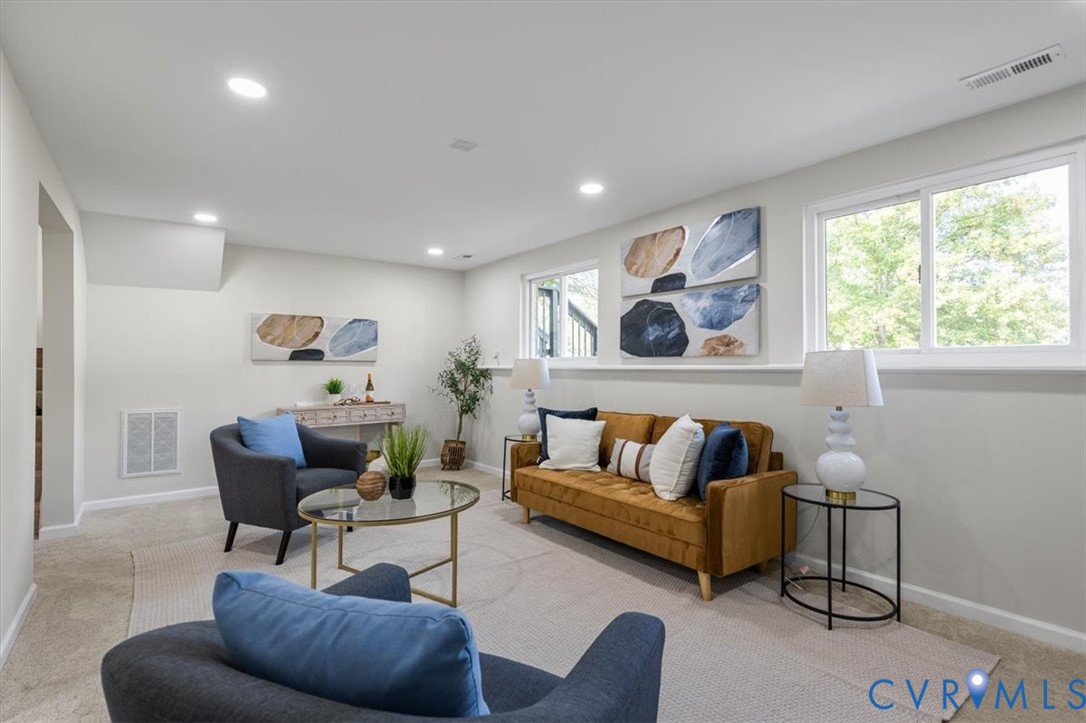 Neutral wall color palette, recessed ceiling lighting, wall-to-wall carpeting, and wide sliding windows with a continuous ledge