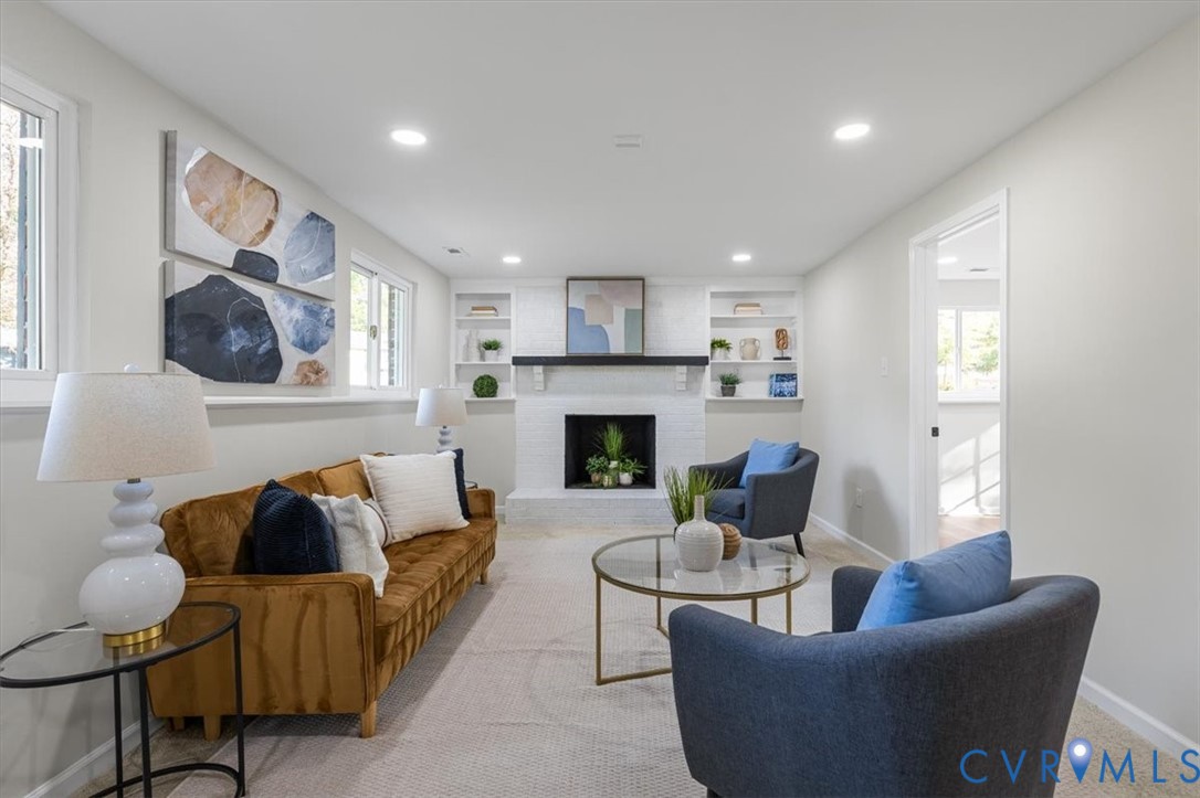 Painted brick fireplace with a dark wood mantel, recessed ceiling lighting, and built-in shelving