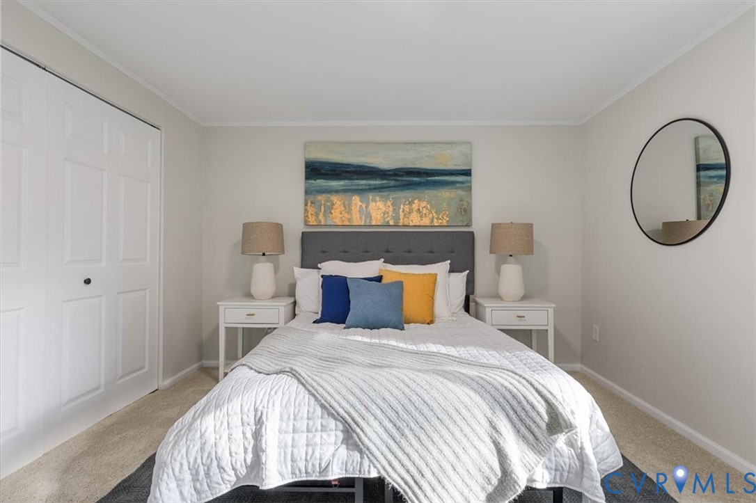 Neutral-toned bedroom featuring wall-to-wall carpeting and a bi-fold closet door