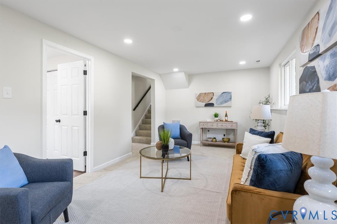 Neutral-toned interior space featuring recessed ceiling lighting, wall-to-wall carpeting, and a multi-panel door