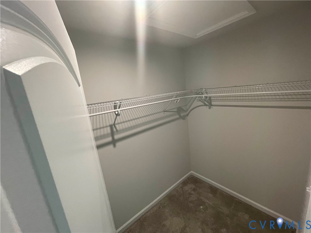 Storage space featuring wall-mounted wire shelving and a paneled interior door