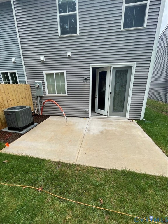 Exterior featuring horizontal gray siding, concrete patio, sliding glass door, and exterior HVAC unit