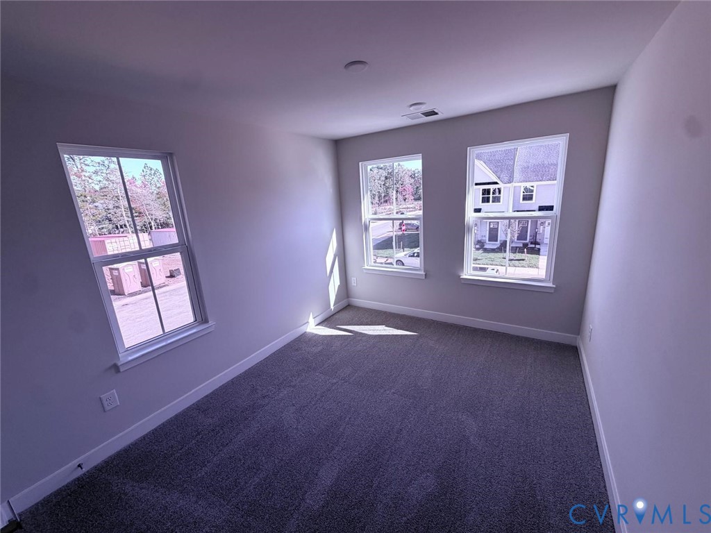 Neutral interior featuring wall-to-wall carpeting and three multi-pane windows