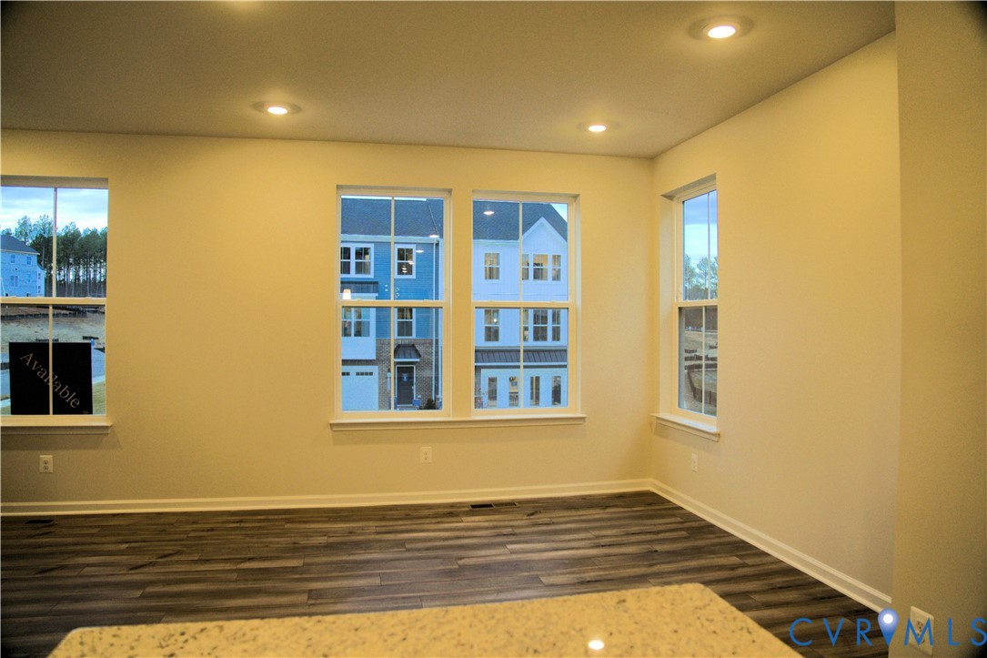 Interior space featuring wood-finish flooring, recessed lighting, and multiple double-hung windows Interior space featuring wood-finish flooring, recessed lighting, and multiple double-hung windows