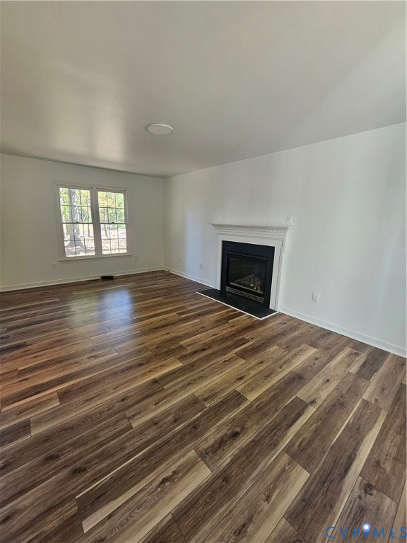 Wood-finish flooring, fireplace with a white mantel, and double-pane window