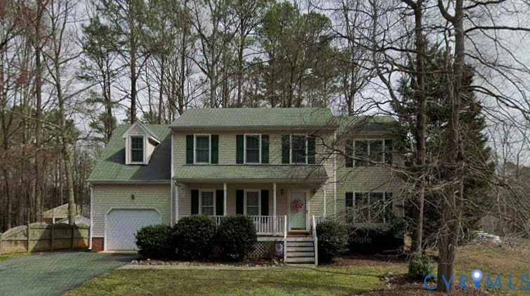Two-story exterior with light-colored siding, dark shutters, gabled roof, covered front porch, and attached garage