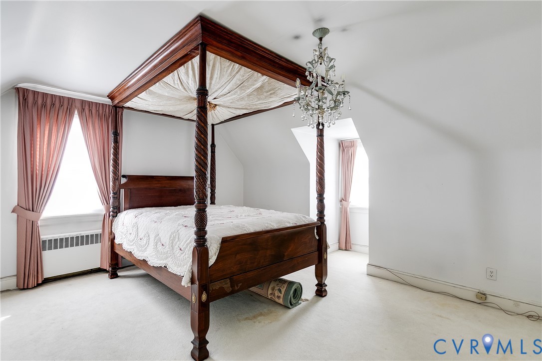Vaulted ceilings featuring a multi-arm crystal chandelier and two recessed dormer windows