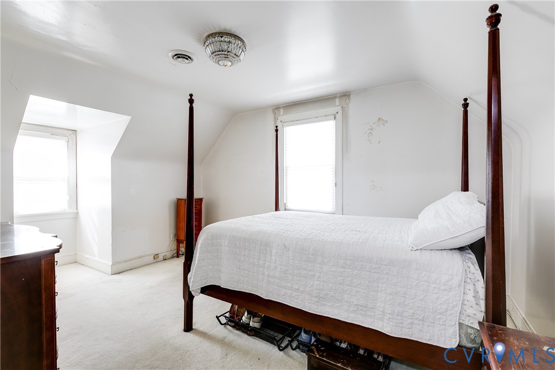 Vaulted ceilings featuring two dormer windows and a decorative flush-mount ceiling fixture