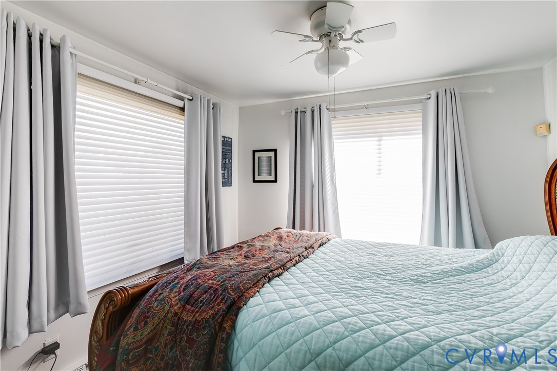 Dual windows with horizontal blinds and ceiling fan with integrated lighting