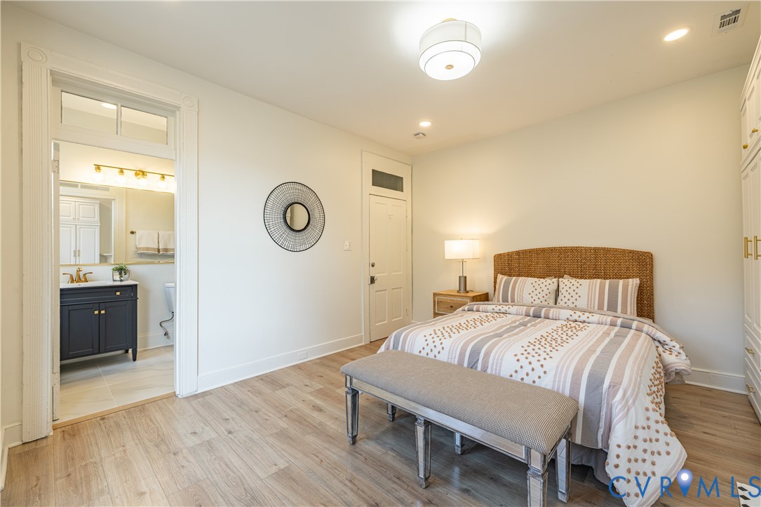 Wood-finish flooring, high ceilings with recessed lighting, integrated transom windows above entry doors, and built-in cabinetry