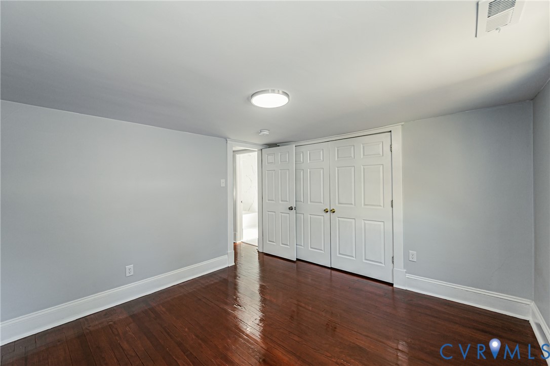 Wood-finish flooring, double-panel closet doors, and flush-mount lighting