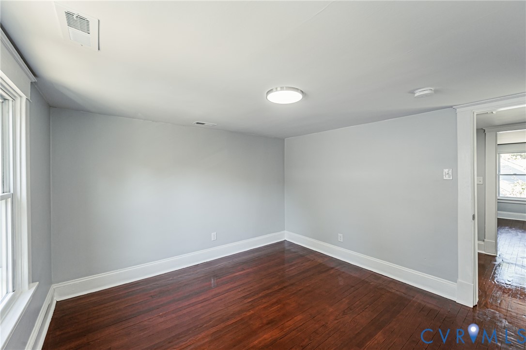 Room featuring wood-finish flooring, neutral wall paint, and overhead flush-mount lighting