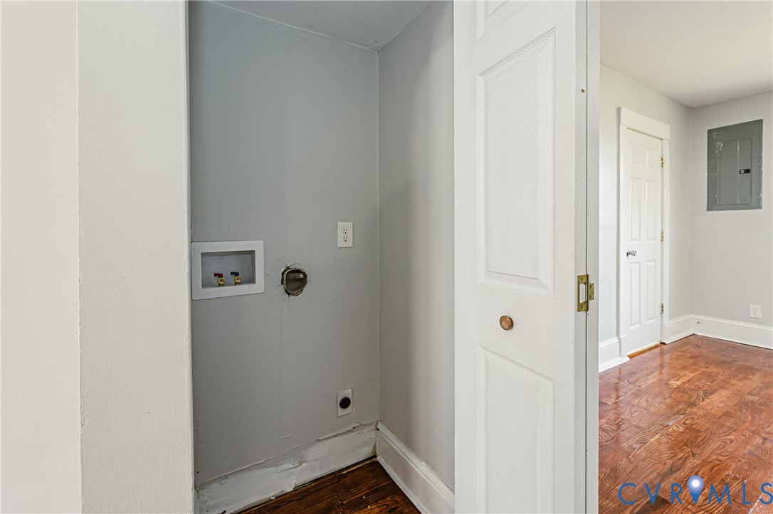 Laundry area featuring wall-mounted water supply and drainage connections, dryer venting, and bifold door access