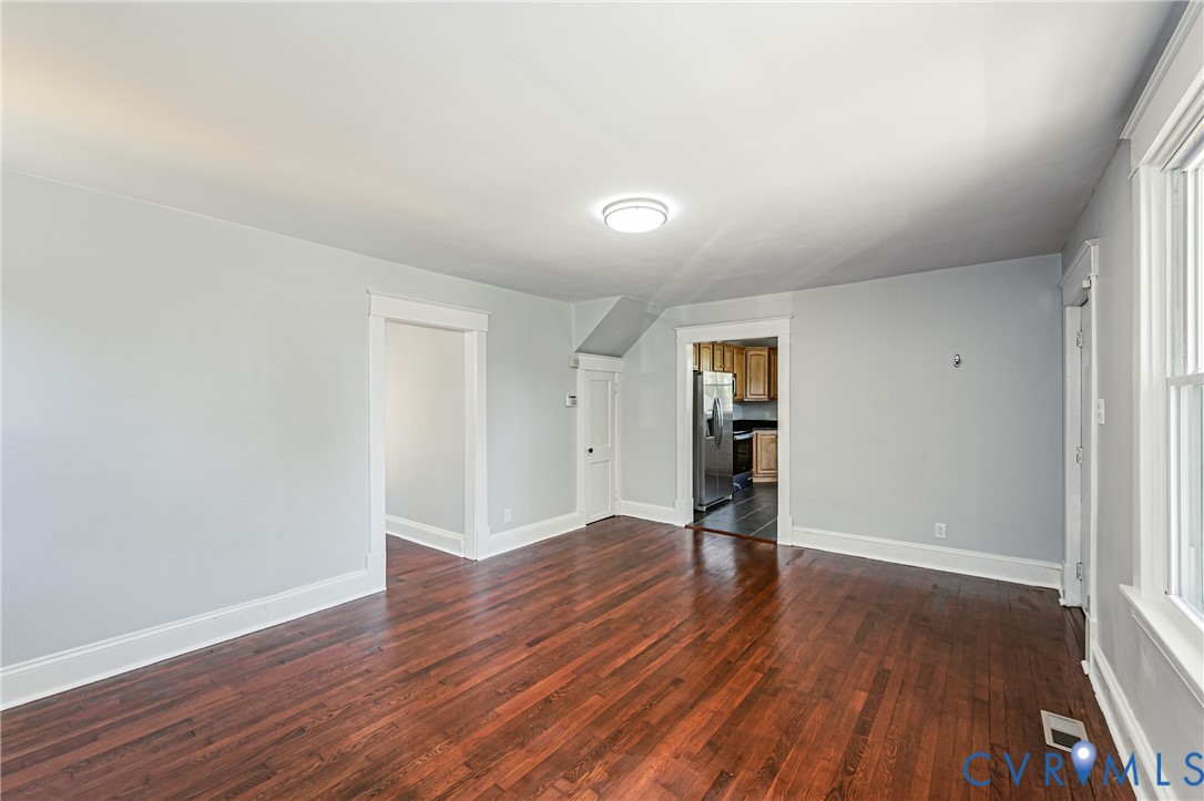 Interior space featuring wood-finish flooring, neutral wall tones, and crown molding