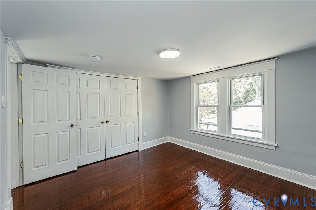 Refinished hardwood flooring, dual-panel interior doors, and double-hung windows with white casing