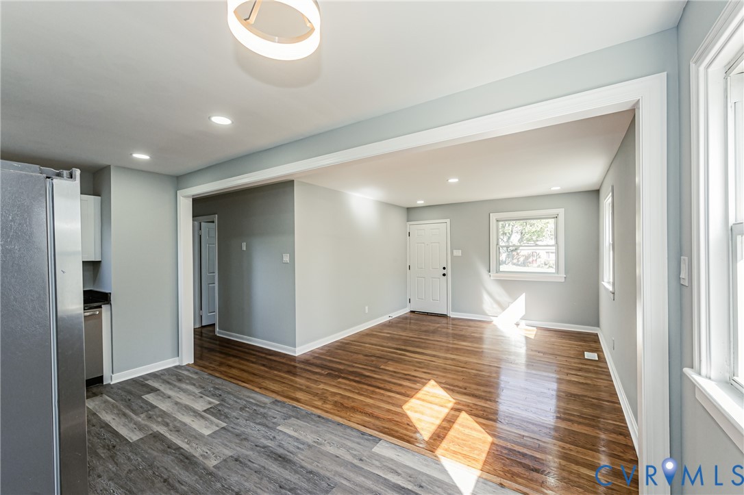 Interior space featuring wood-finish flooring, multi-toned gray plank flooring, recessed lighting, and a modern circular pendant light fixture